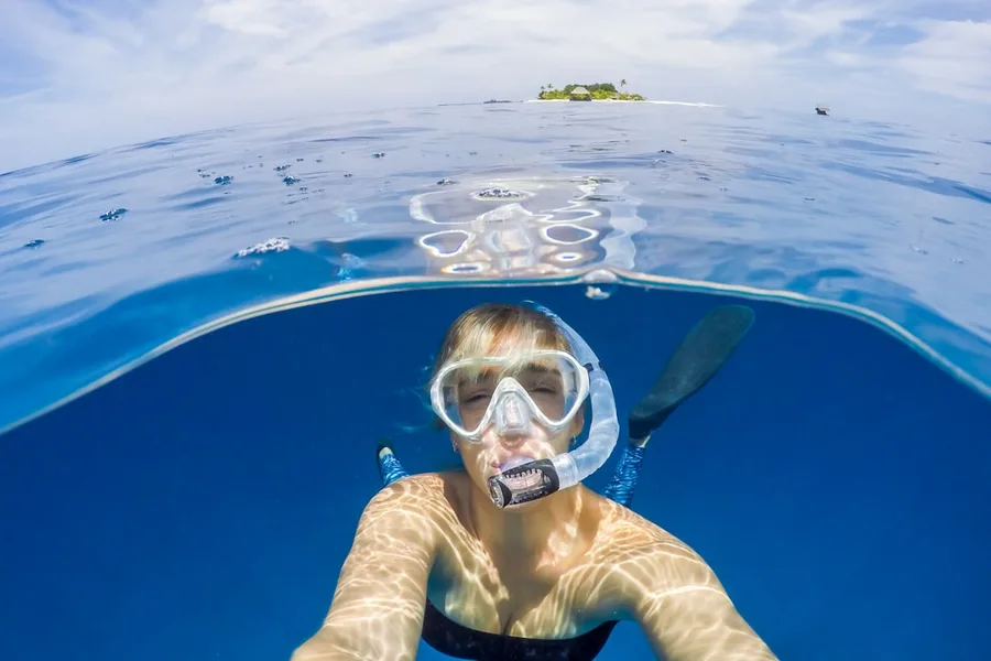 tourist holding travel insurance document snorkeling Maldives Kotor Montenegro