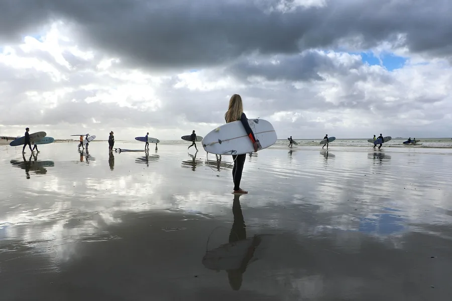 couple surfing Kata Beach Phuket with rental board