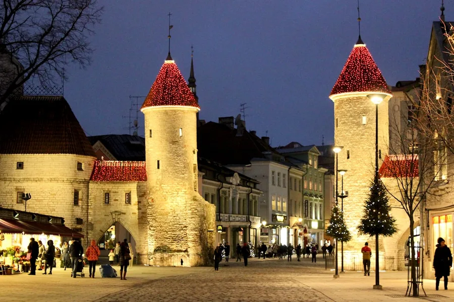 couple walking snowy Tallinn cobblestone street evening Estonia