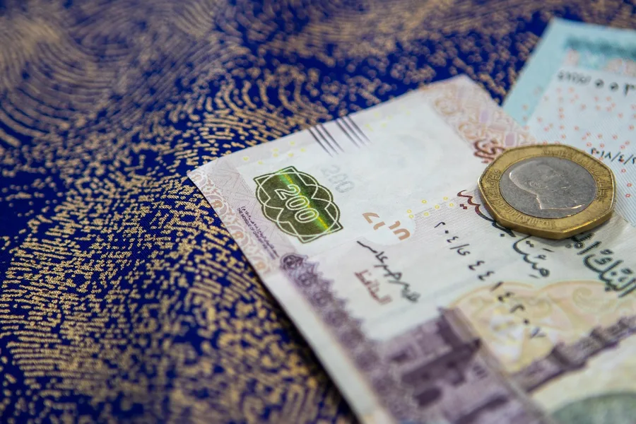 confident woman counting Egyptian pounds after crypto exchange Hurghada cafe