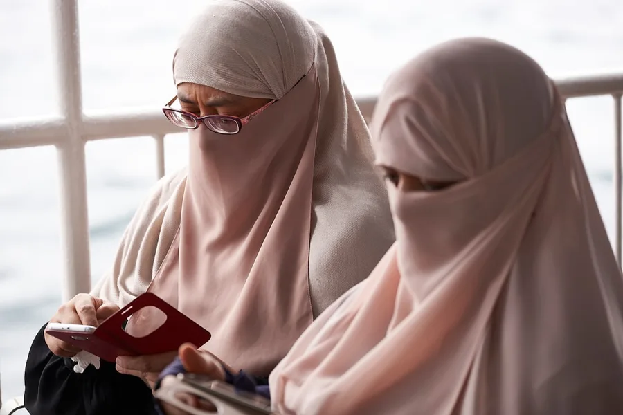 Woman and girl wearing headscarves in mosque Istanbul Turkey