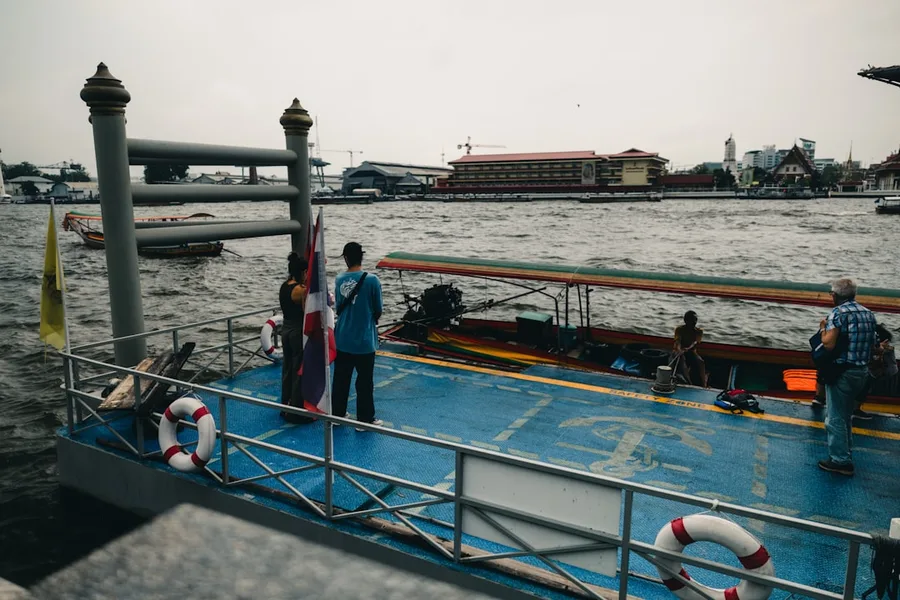 group of tourists with luggage waiting for ferry pier Thailand Bangkok Thailand